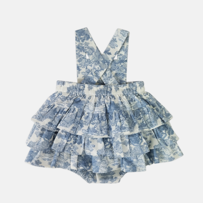 Blue toile ruffled romper with suspenders on a white background