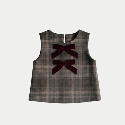 A sleeveless plaid vest in dark brown and gray tones, featuring two dark burgundy velvet bow accents on the front, displayed against a light gray background.