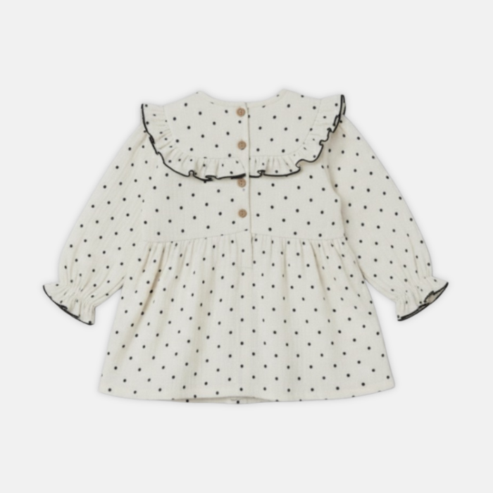 Offwhite dress with black polka dots and a bow on a white background